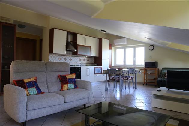 Living con divani e cucina a vista